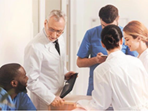 Medical students in scrubs and white coats.