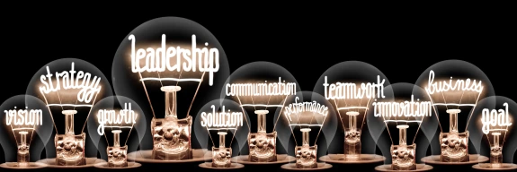 Leadership words illuminated in light bulbs.
