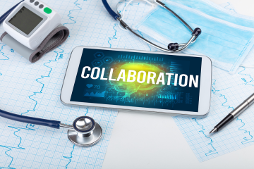 Cell phone screen with the word collaboration displayed next to medical equipment.